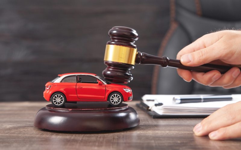 Man striking the gavel over car. Car auction